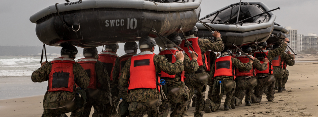 Candidates carrying boat during SWCC training 